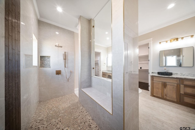 bathroom featuring tiled shower, vanity, and ornamental molding