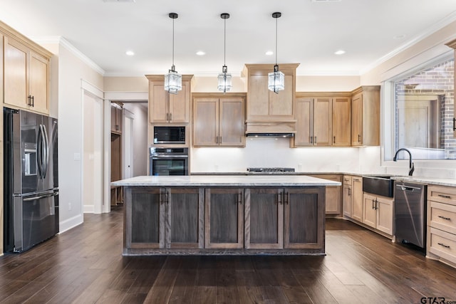 kitchen with appliances with stainless steel finishes, sink, a kitchen island, and pendant lighting