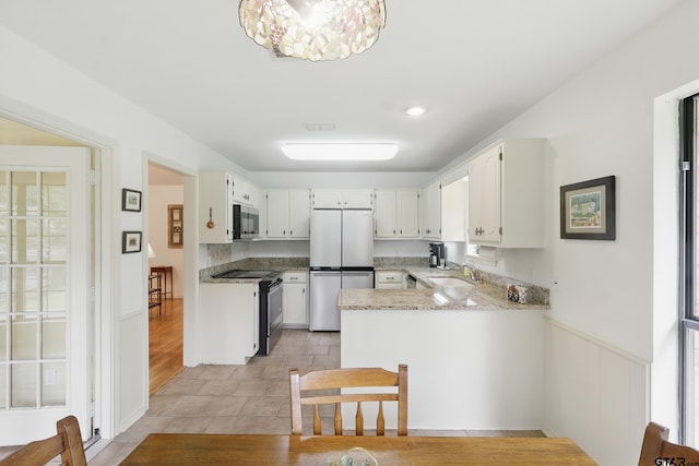 414 Winding Ln, Mount Vernon, TX 75457 - kitchen with stainless steel appliances, a peninsula, light tile patterned flooring, white cabinets, and a chandelier