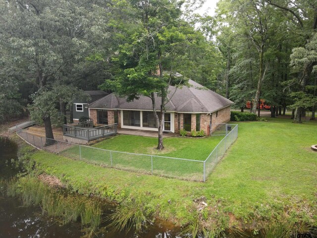 414 Winding Ln, Mount Vernon, TX 75457 - back of property featuring a fenced backyard, brick siding, a shingled roof, a deck, and a wooded view