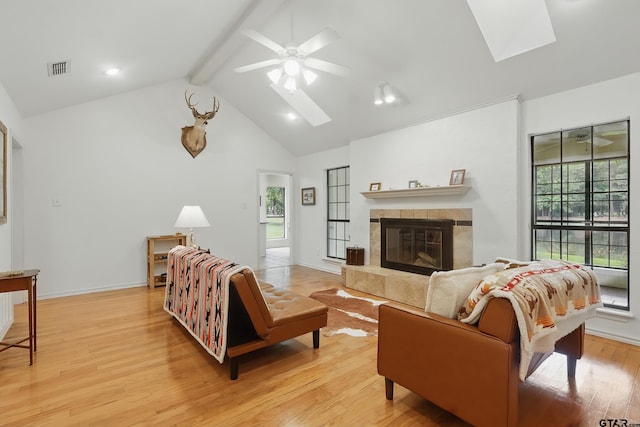 414 Winding Ln, Mount Vernon, TX 75457 - living room featuring a skylight, beam ceiling, light wood finished floors, a fireplace, and a ceiling fan