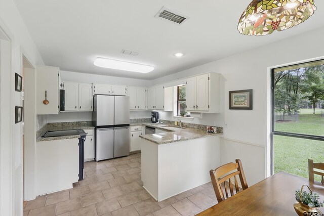 414 Winding Ln, Mount Vernon, TX 75457 - kitchen with stainless steel appliances, a peninsula, and white cabinets