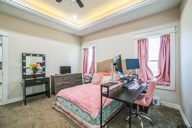 bedroom featuring a ceiling fan, carpet, baseboards, and a tray ceiling