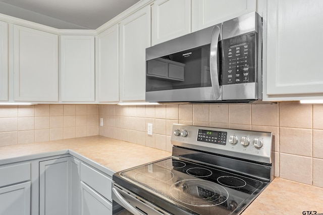 10820 Cactus Trl, Flint, TX 75762 - kitchen featuring appliances with stainless steel finishes, white cabinets, light countertops, and tasteful backsplash
