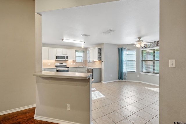 10820 Cactus Trl, Flint, TX 75762 - kitchen with appliances with stainless steel finishes, decorative backsplash, ceiling fan, white cabinetry, and light tile patterned floors