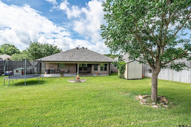 10820 Cactus Trl, Flint, TX 75762 - back of property featuring a trampoline, a storage shed, a patio area, a shingled roof, and a fenced backyard