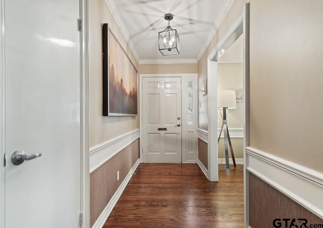 interior space with ornamental molding, dark wood-style flooring, wainscoting, and an inviting chandelier