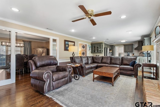 living room with dark hardwood / wood-style flooring, ceiling fan, and ornamental molding