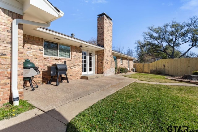 rear view of house with a yard, french doors, and a patio