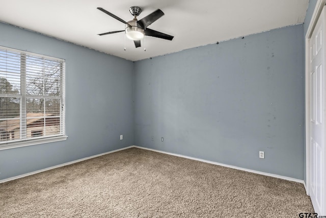 unfurnished room featuring carpet, a ceiling fan, and baseboards