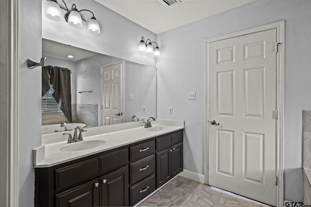 bathroom with double vanity, a sink, baseboards, and tile patterned floors