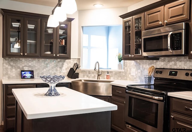 kitchen with hanging light fixtures, sink, tasteful backsplash, and stainless steel appliances