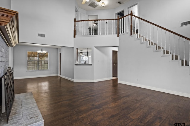 unfurnished living room with a brick fireplace, stairway, and visible vents