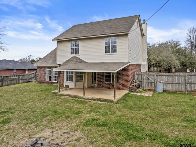 rear view of house with a fenced backyard, a patio, and brick siding