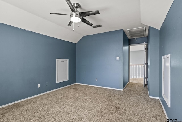 interior space featuring carpet, visible vents, attic access, vaulted ceiling, and baseboards