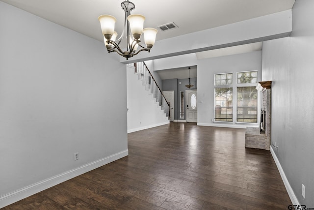 interior space featuring dark wood-style flooring, a notable chandelier, visible vents, stairway, and baseboards