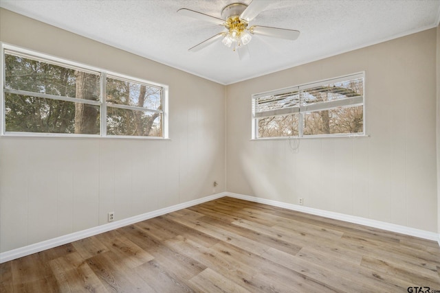 spare room with ceiling fan, a textured ceiling, and light wood-type flooring