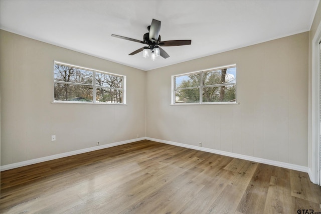 empty room with ceiling fan, a healthy amount of sunlight, and light hardwood / wood-style flooring