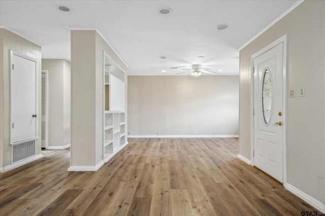 unfurnished room featuring crown molding, ceiling fan, hardwood / wood-style floors, and built in features