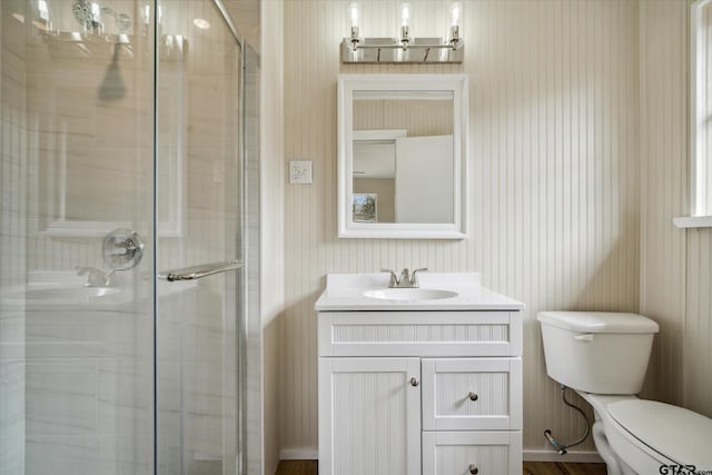 bathroom with an enclosed shower, vanity, and toilet