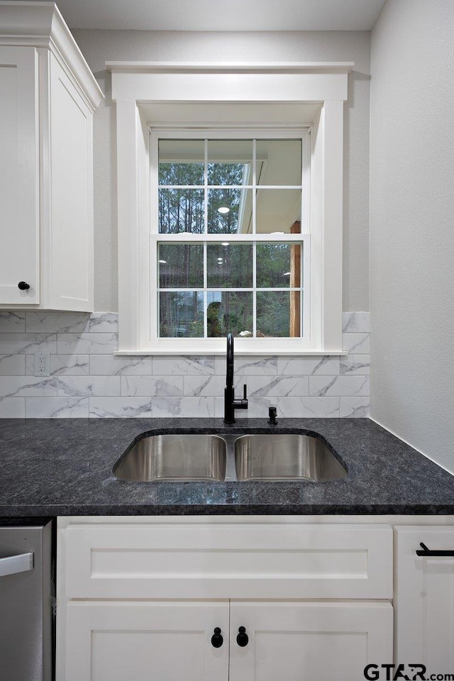 kitchen with sink, dishwasher, white cabinets, dark stone counters, and backsplash