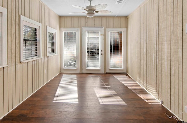 unfurnished room featuring dark wood-type flooring and wood walls