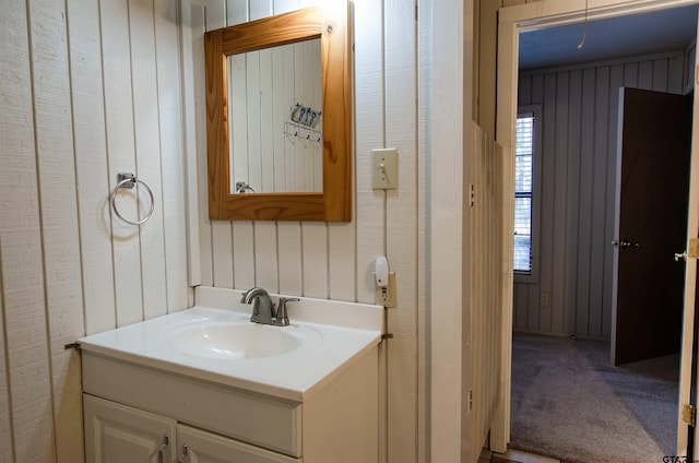 bathroom featuring wood walls and vanity