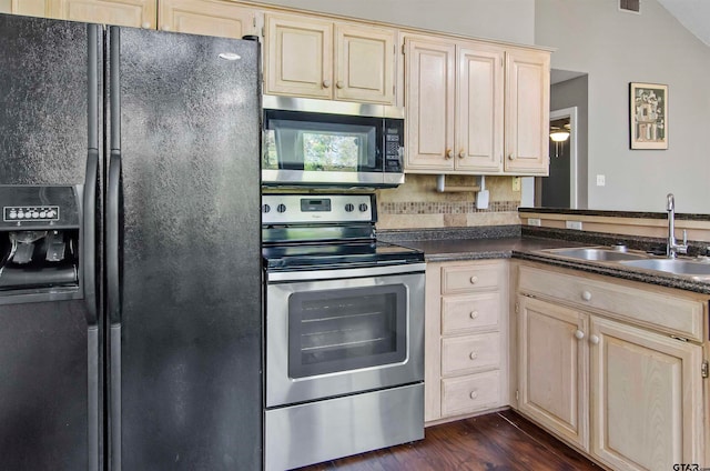 kitchen with stainless steel appliances, dark wood-type flooring, sink, and vaulted ceiling