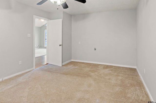 empty room with ceiling fan, a textured ceiling, and light colored carpet