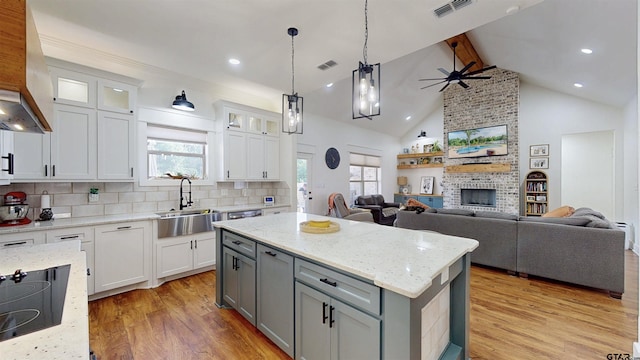 kitchen featuring a sink, a kitchen island, light wood-type flooring, and open floor plan