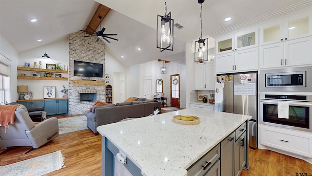 kitchen with open floor plan, appliances with stainless steel finishes, and ceiling fan