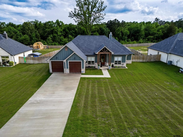 view of front of house featuring a front lawn, board and batten siding, fence, and driveway