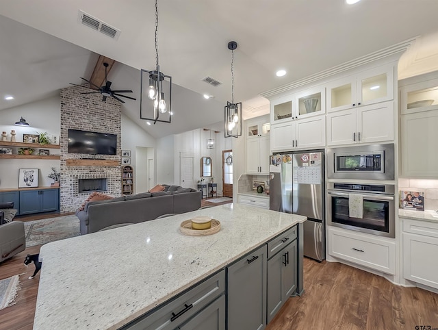 kitchen with a ceiling fan, open floor plan, appliances with stainless steel finishes, and visible vents