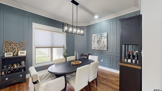 dining area with dark wood-type flooring, baseboards, crown molding, and a decorative wall