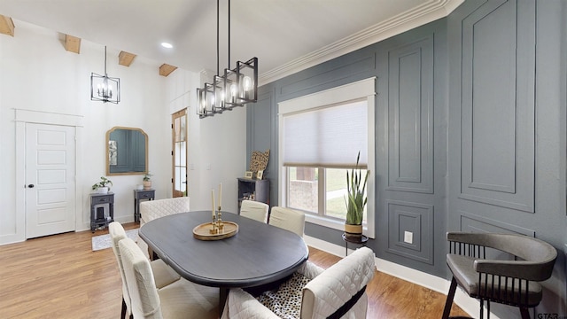 dining room with an inviting chandelier, light wood finished floors, recessed lighting, baseboards, and ornamental molding