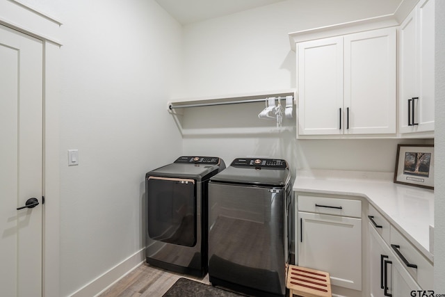 washroom featuring cabinets, washer and dryer, and light wood-type flooring