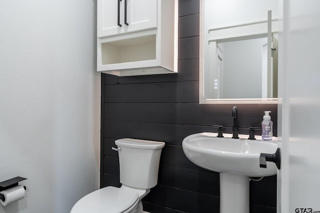 bathroom with tile walls and toilet