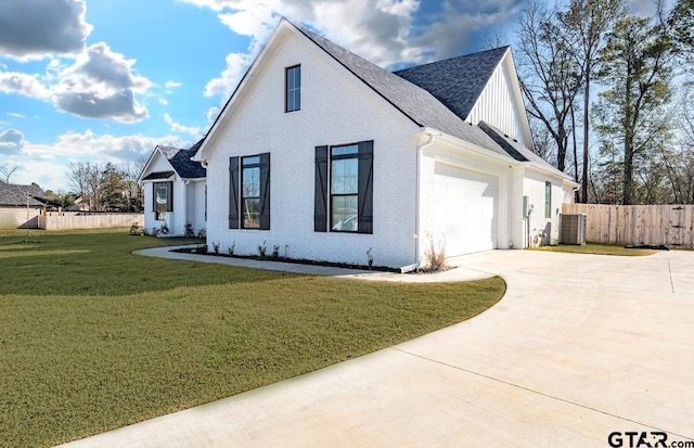 exterior space with a garage, a front yard, and central AC