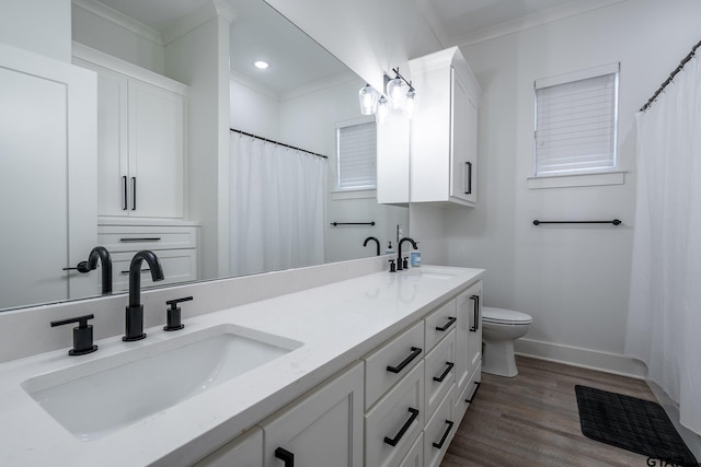 bathroom featuring toilet, hardwood / wood-style floors, vanity, and crown molding