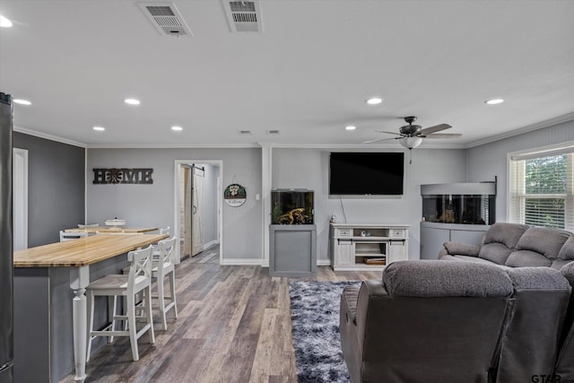 living room featuring hardwood / wood-style floors, ceiling fan, and ornamental molding