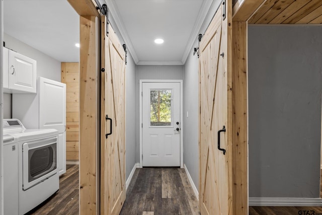 laundry area featuring ornamental molding, a barn door, cabinets, dark wood-type flooring, and independent washer and dryer