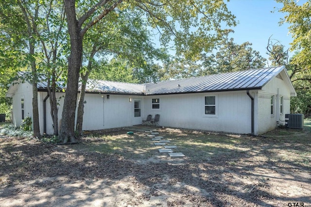 rear view of house with central AC unit and a patio