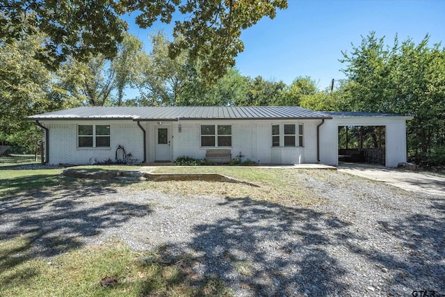 ranch-style home featuring a carport and a front yard