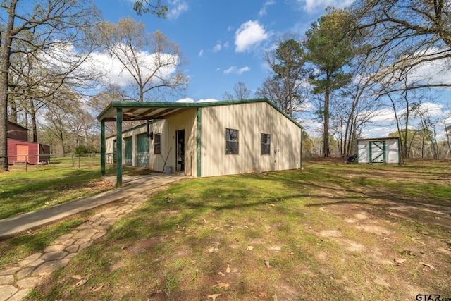 back of house featuring a lawn and a shed