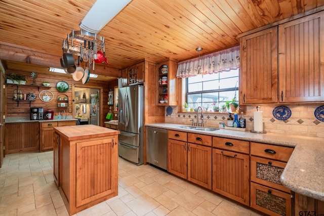 kitchen featuring butcher block countertops, decorative light fixtures, sink, a center island, and stainless steel appliances