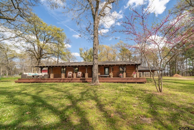 back of property with a wooden deck and a yard