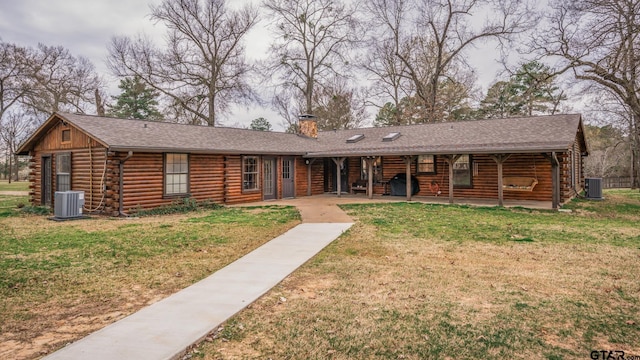 log home featuring a front lawn and central air condition unit