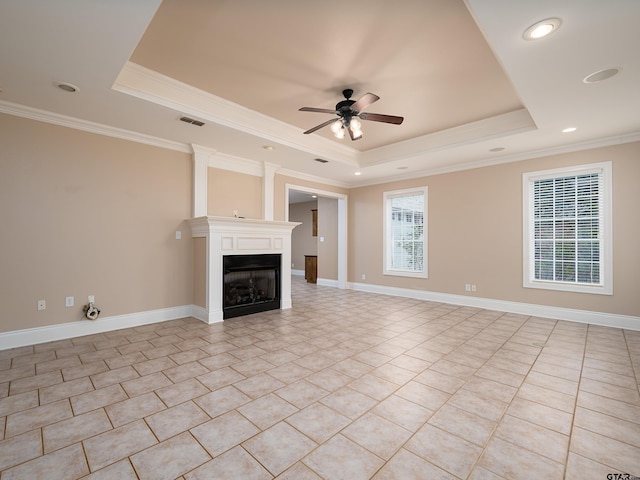 unfurnished living room featuring a ceiling fan, a raised ceiling, ornamental molding, and visible vents