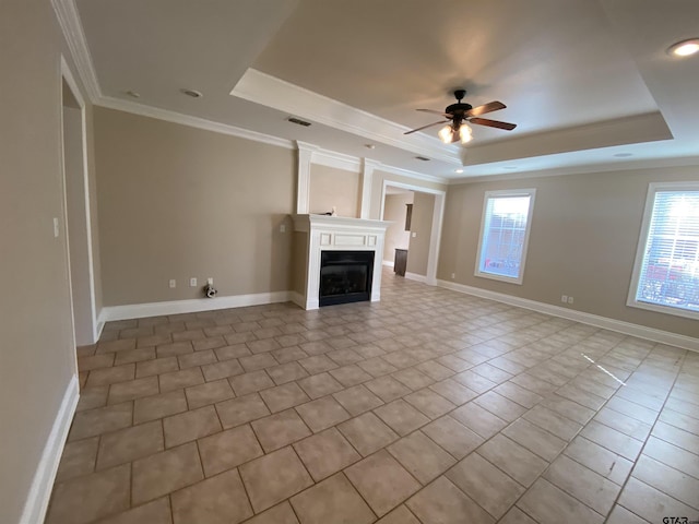 unfurnished living room with crown molding, ceiling fan, and a raised ceiling