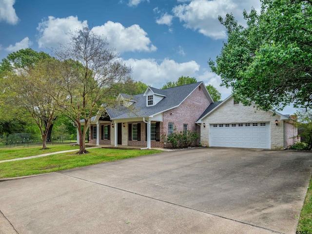 view of front of home featuring an attached garage, driveway, a front yard, brick siding, and a porch